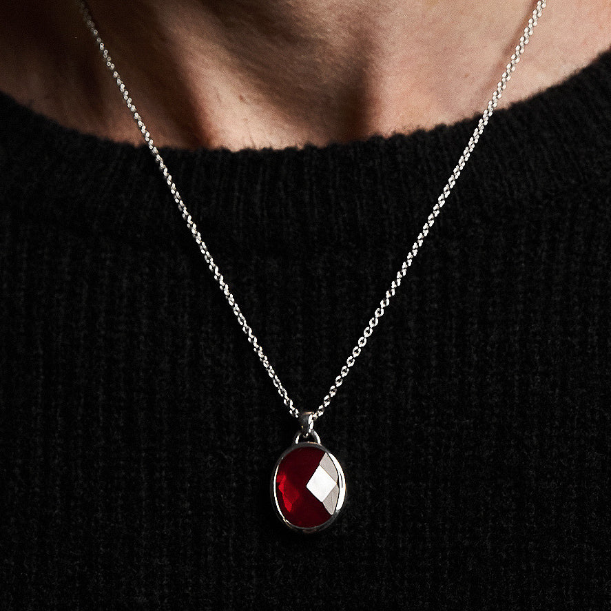 A person wearing the Suki Red Garnet Pendant, showcasing the rose-cut garnet set in sterling silver on a 52cm hammered chain.