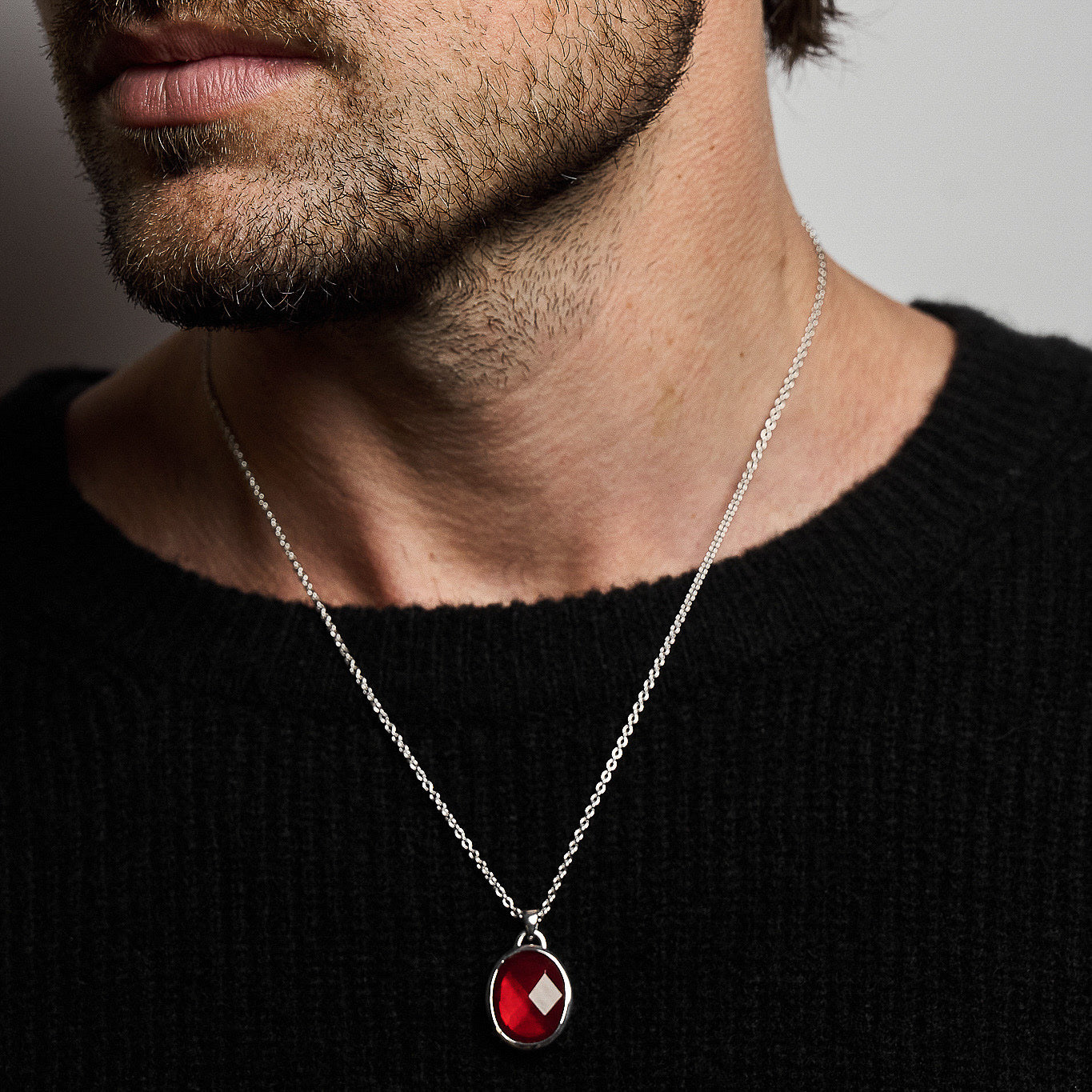 A person wearing the Suki Red Garnet Pendant, showcasing the rose-cut garnet set in sterling silver on a 52cm hammered chain.