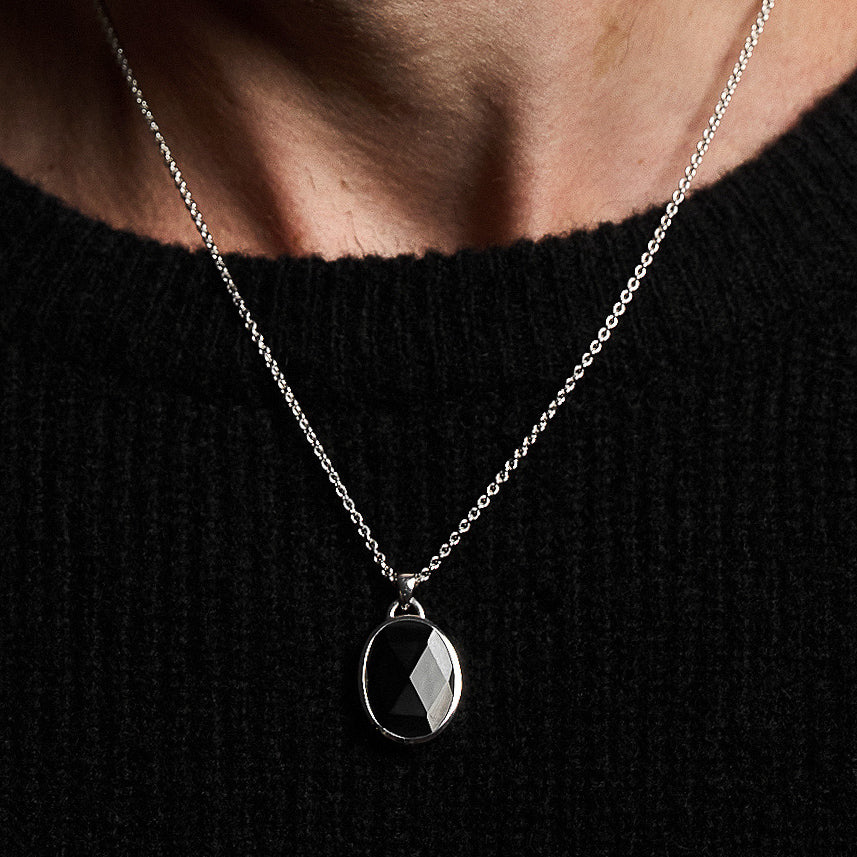 Close-up of a person wearing the Suki Onyx Pendant, showcasing the rose-cut black onyx set in rhodium-plated sterling silver on a 52cm hammered chain.