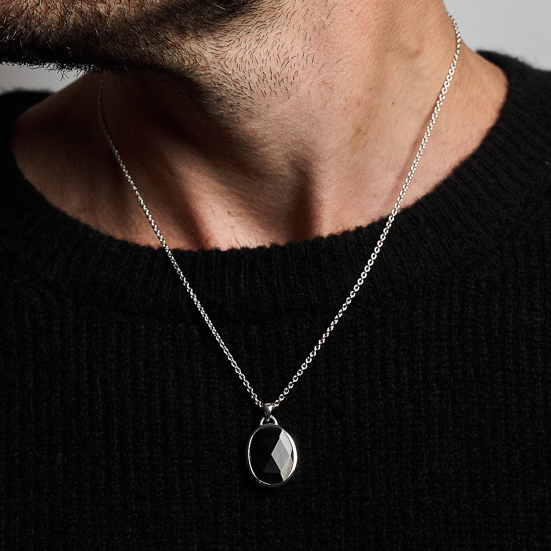 Close-up of a person wearing the Suki Onyx Pendant, showcasing the rose-cut black onyx set in rhodium-plated sterling silver on a 52cm hammered chain.