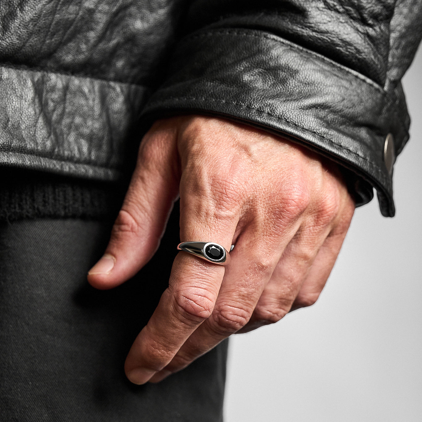 Close-up of a person wearing the Yuki Onyx Signet Ring, showcasing the rose-cut black onyx set in high-polish rhodium-plated sterling silver.