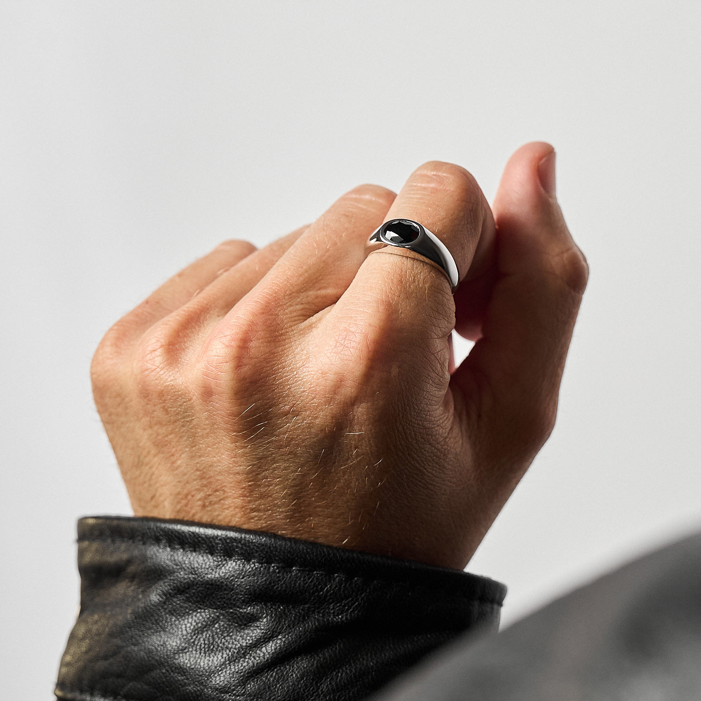 Close-up of a person wearing the Yuki Onyx Signet Ring, showcasing the rose-cut black onyx set in high-polish rhodium-plated sterling silver.