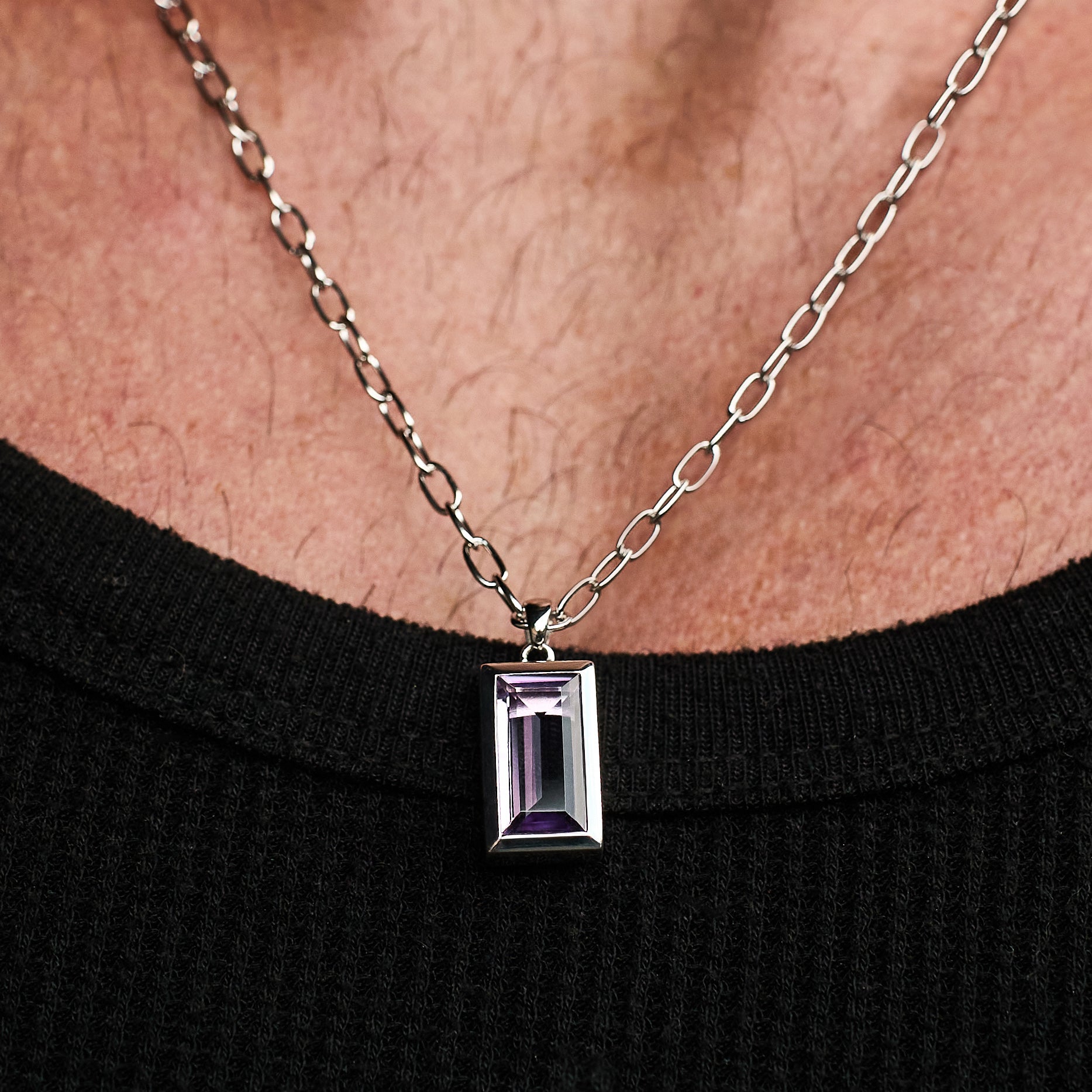 Close-up of a person wearing the Amethyst Pendant, featuring a natural baguette-cut amethyst stone set in rhodium-plated sterling silver with a 55cm sterling silver chain.