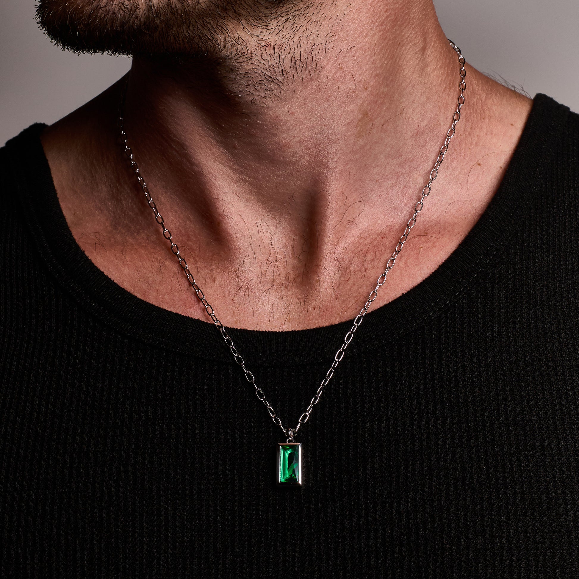 closeup shot A man wearing Sona Emerald Pendant 