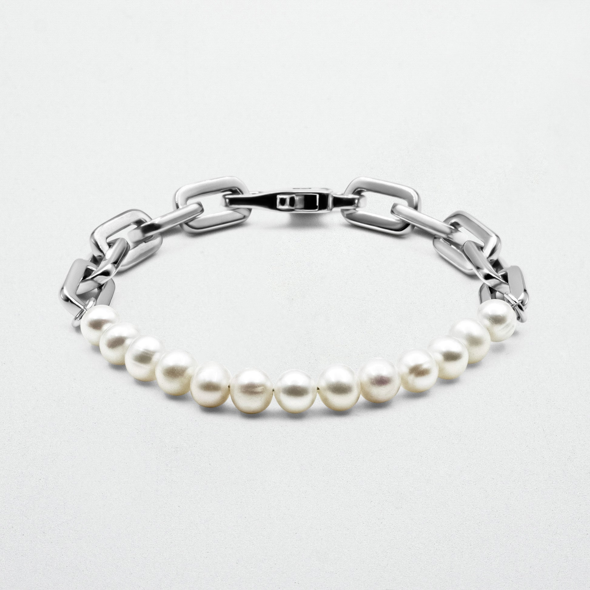 Axel Pearl Bracelet featuring smooth freshwater pearls and high-polish rhodium-plated recycled sterling silver, secured with a robust clasp and signature logo.