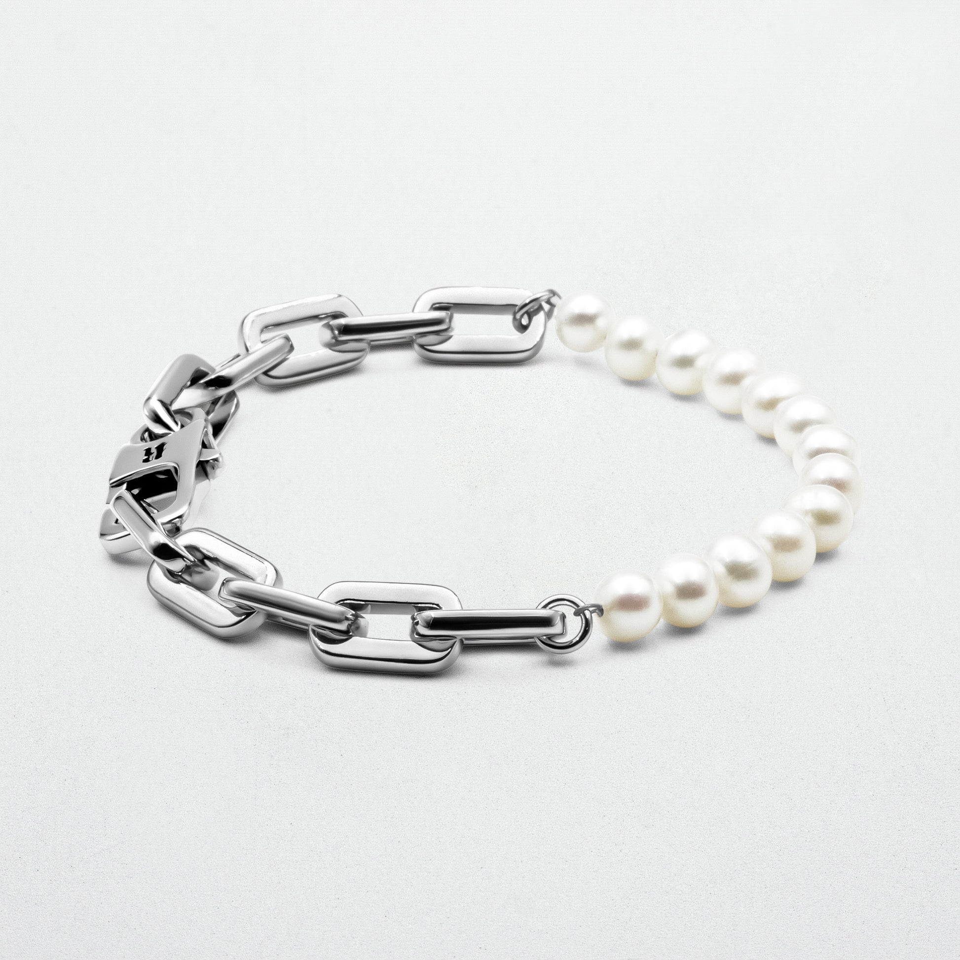  Axel Pearl Bracelet featuring smooth freshwater pearls and high-polish rhodium-plated recycled sterling silver, secured with a robust clasp and signature logo.