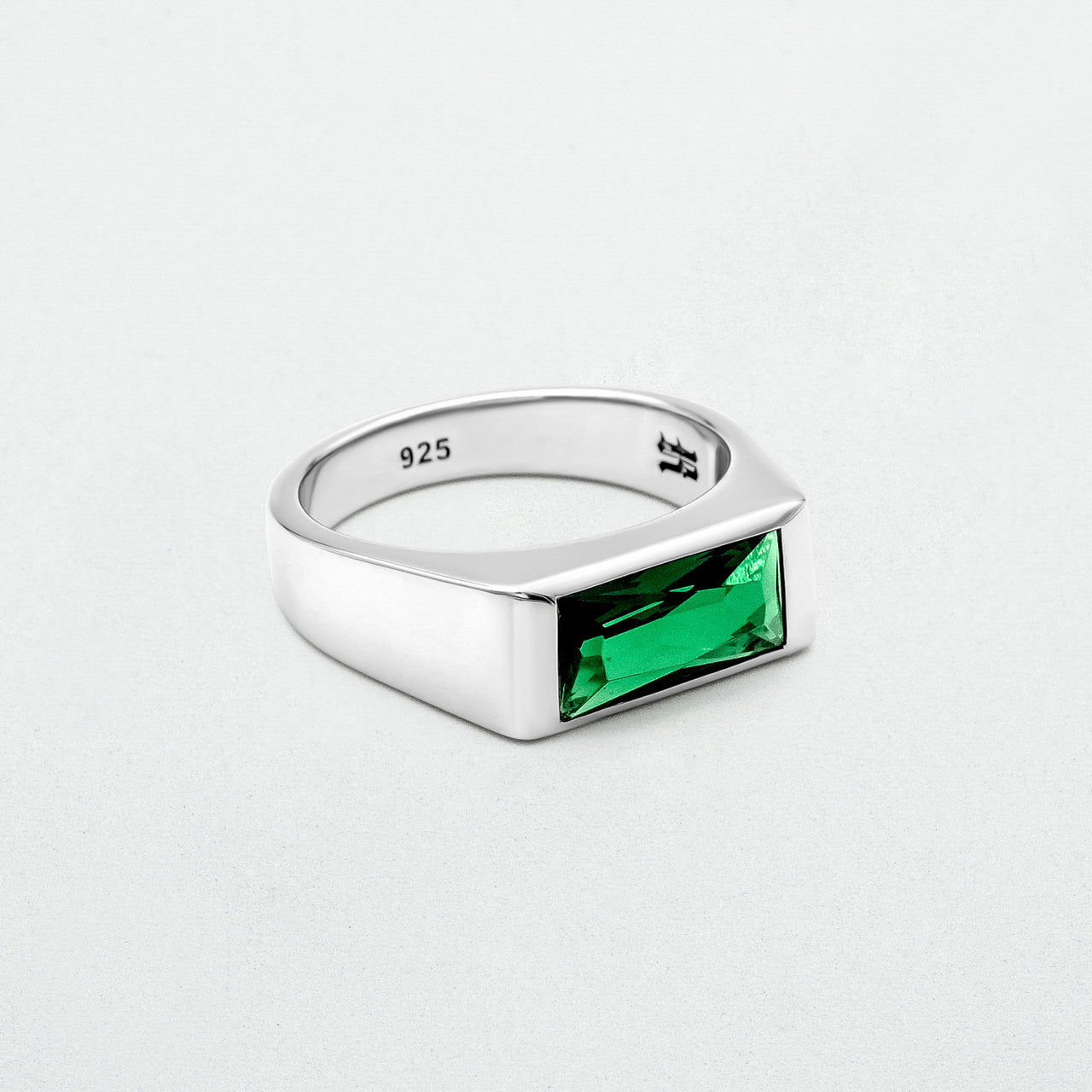 Emerald Signet Ring with a green baguette-cut glass stone set in high-polish rhodium-plated sterling silver. A bold yet minimalist design.