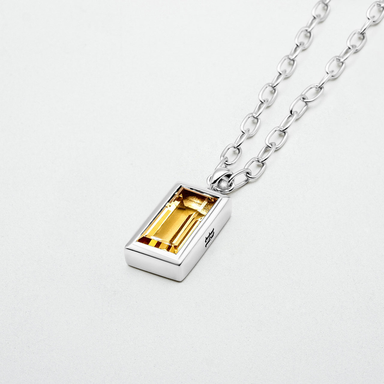 Citrine Pendant featuring a baguette-cut citrine stone set in rhodium-plated recycled sterling silver, hanging from a 55cm sterling silver chain.