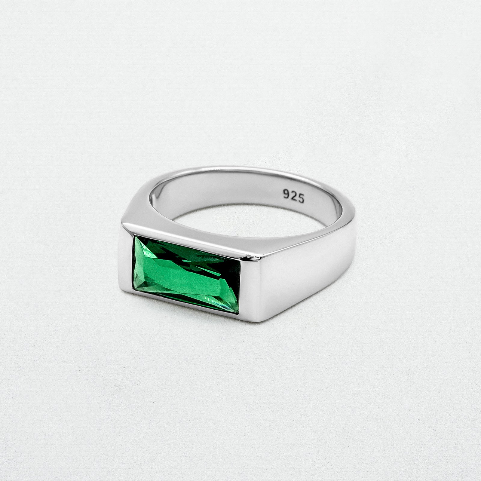 Emerald Signet Ring with a green baguette-cut glass stone set in high-polish rhodium-plated sterling silver. A bold yet minimalist design.