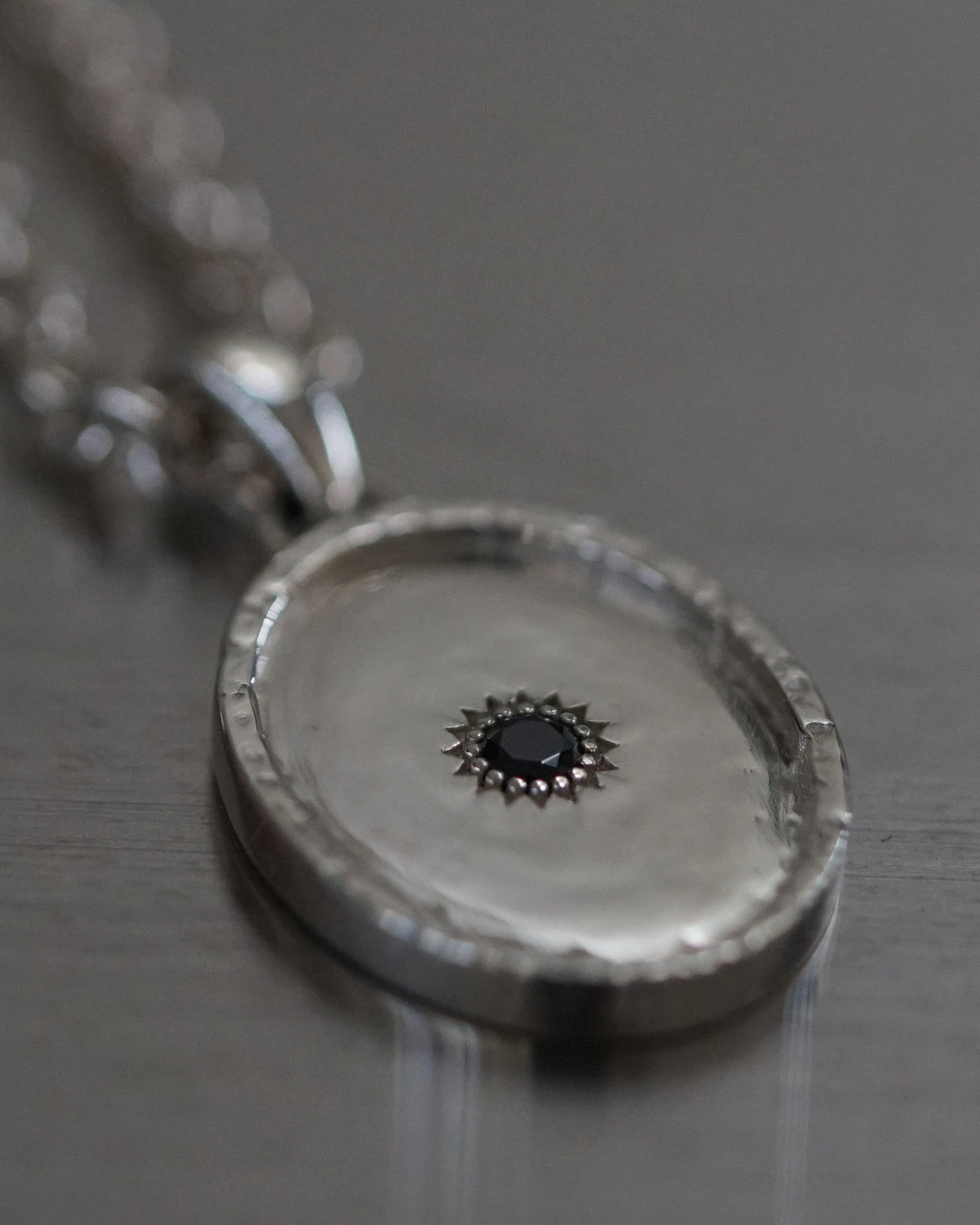 Close-up of the Sol Pendant featuring a black stone set in solid 925 sterling silver.